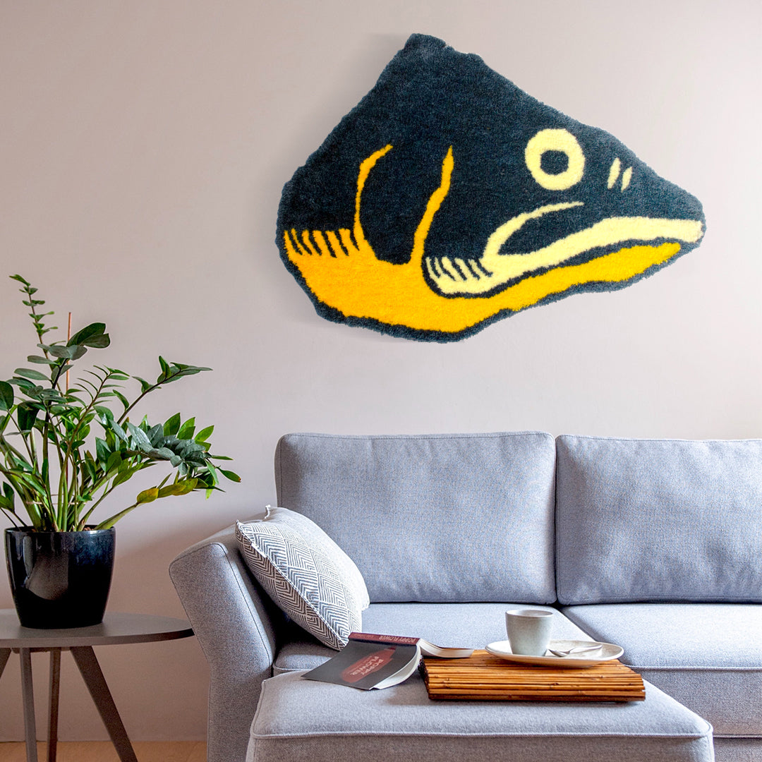 studio yarnatak blue and yellow fish head on wall above grey sofa