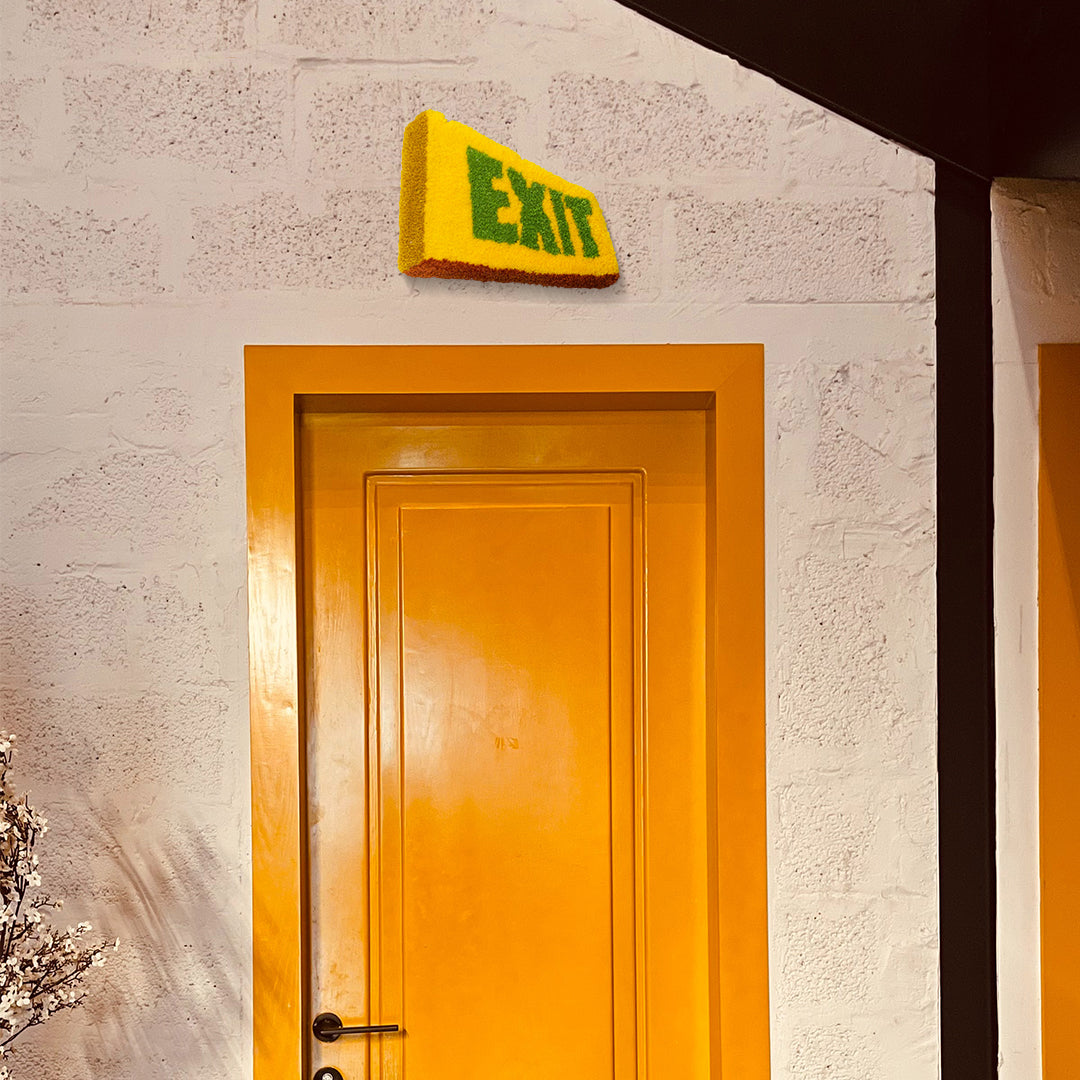 studio yarnatak exit small wall rug above yellow door on white concrete wall